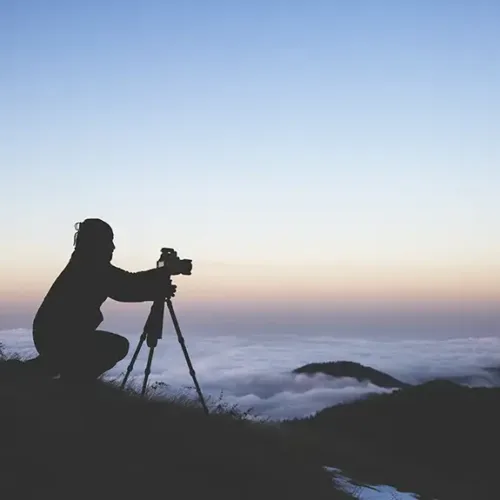 silhouette-photographer-setting-up-camera-shoot-sea-clouds-sunset copy